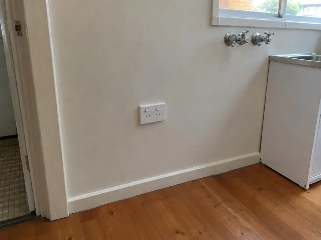 White double power point on a painted kitchen wall beside a sink and timber floor in Gorokan